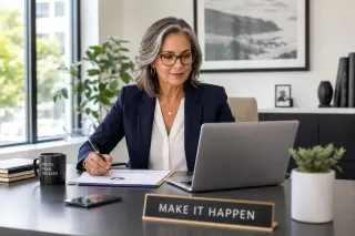 Confident woman in her early 50s interviewing for a job in a modern, sunlit office, engaged in conversation with a recruiter.